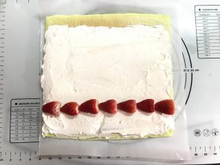 草莓斑斓蛋糕卷,等蛋糕冷却后，将蛋糕翻面撕掉底部油纸。淡奶油加10克奶粉10克糖打发至偏干性，抹在蛋糕上，起始端稍厚，尾部稍薄并留2-3cm不抹奶油，放上草莓。