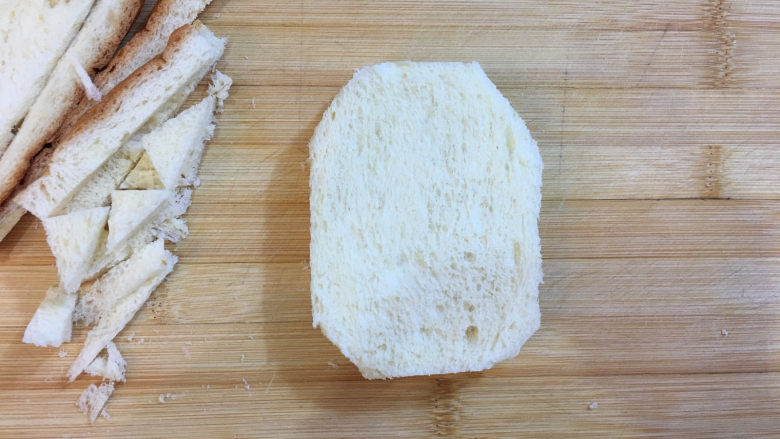 童趣早餐——乌龟全麦三明治,先将面包片四周切去，切成近似椭圆形。