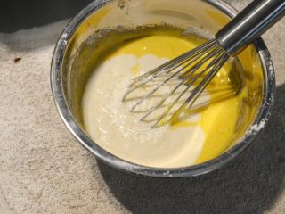 夏日清爽柠檬乳酪杯子蛋糕,混合搅拌均匀的两份面糊，倒在一起，混合均匀。这样把面粉分成两部分加入到液体材料中，能够最大限度的减少面粉颗粒，并且混合的更为均匀