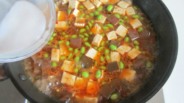 毛豆米双色豆腐,加入适量的水淀粉勾芡， 大火收汁即可盛入盘中。
