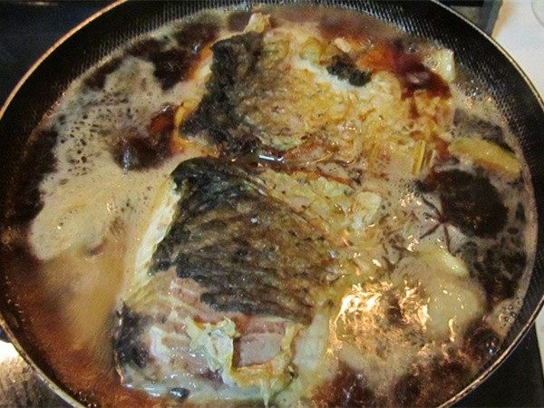 侉炖鱼,汤开煮开后下入刚才煎好的鱼；