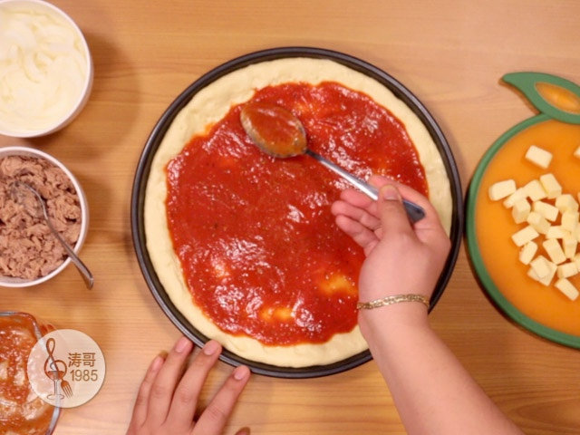 金枪鱼披萨，味道鲜美，馅料十足,做大披萨的时候也是按照相同的顺序，先放披萨酱