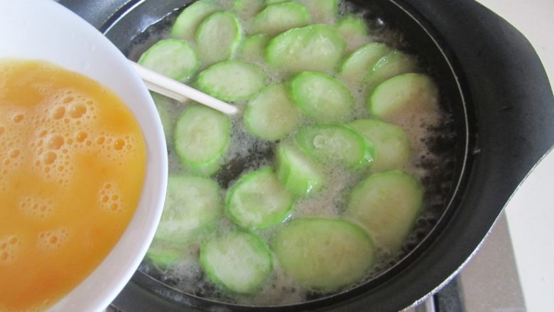 丝瓜猪肝蛋花汤,开大火，将打散的蛋液顺着筷子倒入，蛋花浮起来就关火，这样很容易形成漂亮的蛋花，盛入碗中， 撒上小葱末。