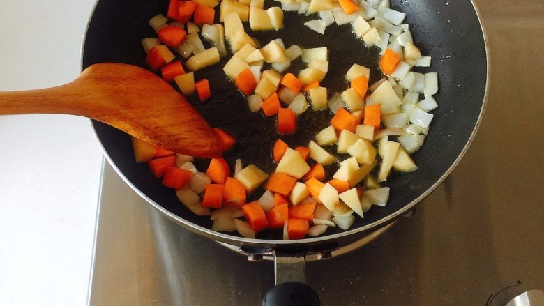 咖喱芝士热狗意面,然后倒入胡萝卜和土豆丁，翻炒均匀；