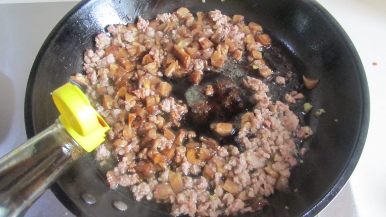 肉末香菇烧麦（饺子皮版）,翻炒几下后再倒入适量的味极鲜翻炒上色， 再加入泡香菇的水， 炖煮两分钟；