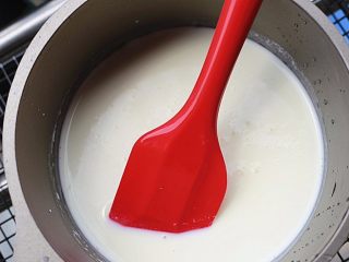 奶香浓郁哒-花生小奶糕,将拌匀的液体倒入奶锅中，小火加热，并用刮刀不停的搅拌，以免结块或是粘底