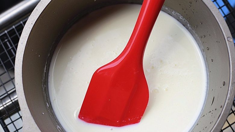奶香浓郁哒-花生小奶糕,将拌匀的液体倒入奶锅中，小火加热，并用刮刀不停的搅拌，以免结块或是粘底