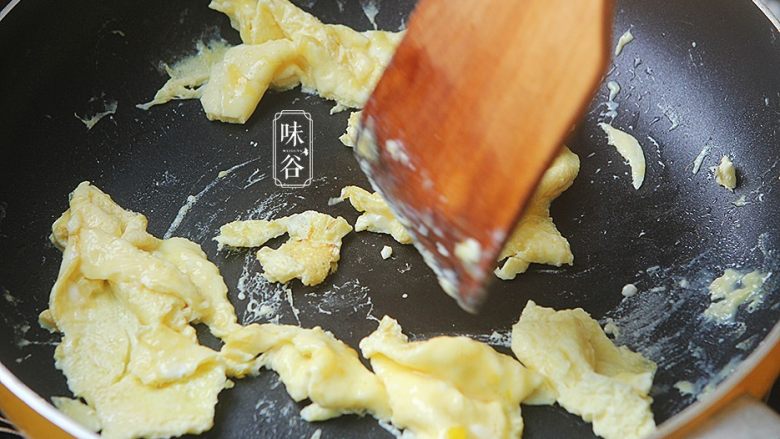 南瓜花炒鸡蛋,鸡蛋表面起泡后用铲把鸡蛋炒碎;
