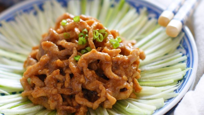 京酱肉丝：好吃易做经典菜,将肉丝盛入葱丝盘中。