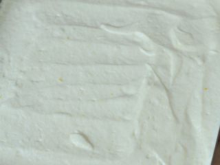 QQ糖抹茶慕斯,蛋白糊和蛋黄糊混合均匀，倒入不粘烤盘中，用刮刀抹平表面。（不粘烤盘里不需要垫油纸。）放入烤箱中，180度烤16分钟，烤至表面金黄。 