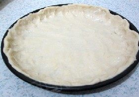 芝心香肠苹果披萨,发酵好的面团，用擀面杖擀成圆形，放入烤盘中