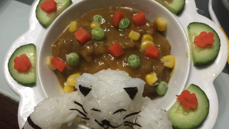 小猫咪咖喱牛肉饭,加入适量的咖喱牛肉，撒上绰过水的杂蔬粒即可