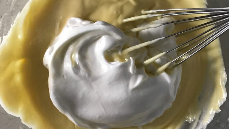 百香果芝士蛋糕, 继续取三分之一蛋白霜放入蛋黄糊中同样手法翻拌均匀。