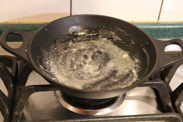 Dutch baby松饼,自烤箱取出铸铁锅,小心您的手和家里的桌子，将一大匙奶油放入，摇动铁锅让奶油布满整个锅面。