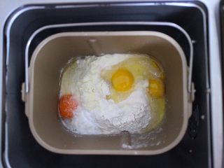 沙琪玛,将面粉和奶粉还有鸡蛋倒入到面包桶内（鸡蛋先放三个，另外鸡蛋稍微选个大一点的）