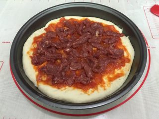 牛肉田园披萨,12. 在饼皮上抹一层披萨酱，把牛肉摆放好