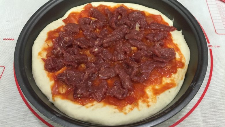 牛肉田园披萨,12. 在饼皮上抹一层披萨酱，把牛肉摆放好