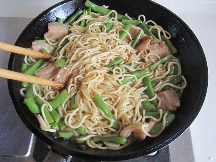 扁豆焖面,关火， 用筷子将它们搅拌均匀，盛入盘中。