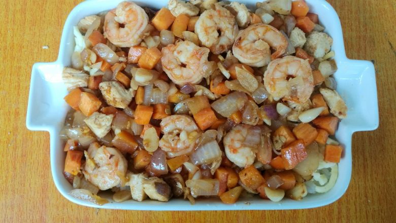 鲜虾仁焗饭,把炒好的鲜虾铺在焗饭盘。