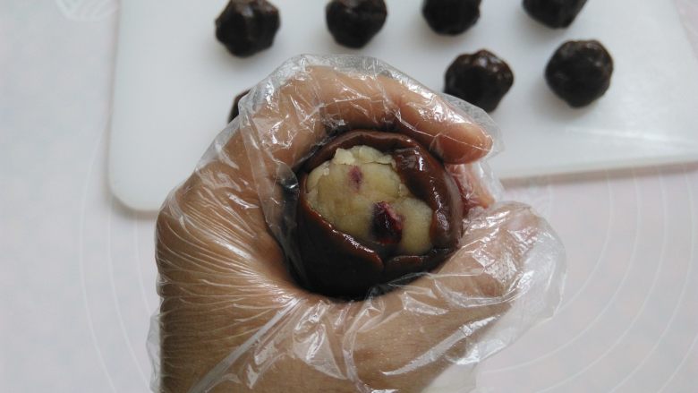 巧克力蔓越莓莲蓉月饼,手心合起来，用虎口把面团慢慢收圆，皮厚的地方可以推到皮薄的地方，尽量推的均匀一点