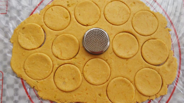 万圣节不给糖就捣蛋——南瓜饼干,南瓜面团擀成一个大面饼，用一个大的圆形工具印出饼干胚