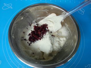 酸奶蔓越莓饼干,筛入低筋面粉，加入蔓越莓干，用硅胶刮刀翻拌均匀。