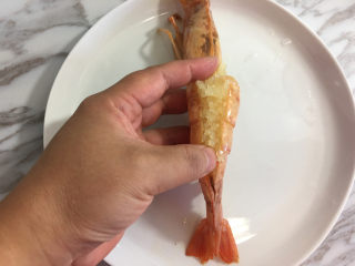 面包机版蒜蓉芝士烤大虾,腌制完成后从虾背打开剪开的虾皮，放入蒜蓉。