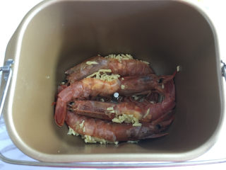 面包机版蒜蓉芝士烤大虾,将整理好的大虾整齐的摆入面包机桶内。