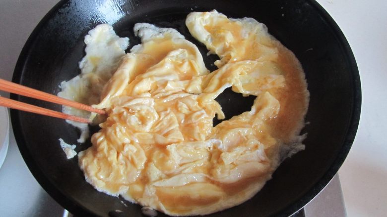 荷兰豆海鲜菇炒鸡蛋,热锅凉油，倒入打散的鸡蛋液，微微煎至定型用筷子划成小块， 盛出备用；