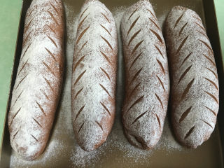 麻薯夹心可可味软欧,发酵完成后取出，面包表面撒上干粉，用锋利的刀割出花纹。