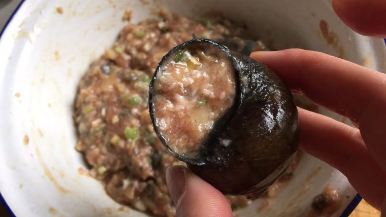 田螺塞肉,取一个空螺壳，用勺子取适量馅料填入空里