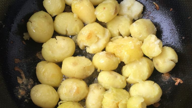 香辣香草小土豆,用铲子将土豆压扁，煎至土豆两面金黄，表皮变脆