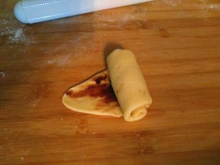   红豆吐司包,把面团从上往下卷起来，卷的时侯两边要收紧一点。(这样才能放进模具里)