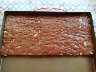巧克力牛轧糖（耐烤巧克力版）,把混合均匀的牛轧糖倒入到不沾的烤盘（或者油纸上）