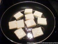 豆腐甘蓝便当,平底锅放少许油。放入豆腐片。