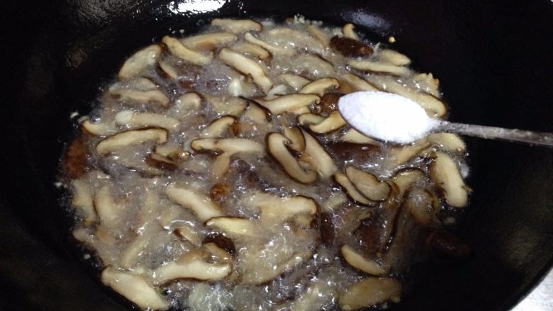 香菇菌子油,待香菇炸软出汁后放入适量的盐（约5克左右）继续炸