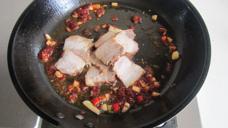 青椒素鸡炒回锅肉,翻炒出红油后加入卤肉进去煸炒；