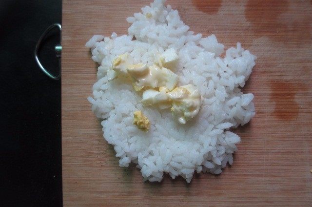 日式烤饭团,先放入少量米饭，放入一勺拌匀的鸡蛋料，然后再铺一层米饭在上面