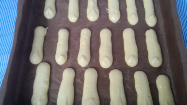 手指饼干,在铺了油纸或油布的烤盘上挤出长条形。