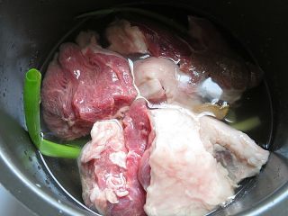 羊肉泡馓子,电饭煲内铺上葱段、姜片，放入羊肉和没过羊肉的水，设置羊肉键炖30分钟，不要炖的太烂