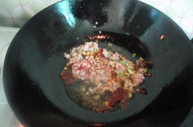 肉沫茄子煲,然后把肉馅、豆瓣酱倒进去继续翻炒。