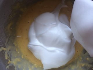 香橙蛋糕,将三分之一打发好的蛋白加到蛋黄糊中，翻拌均匀后倒入剩余的蛋白中，翻拌均匀。