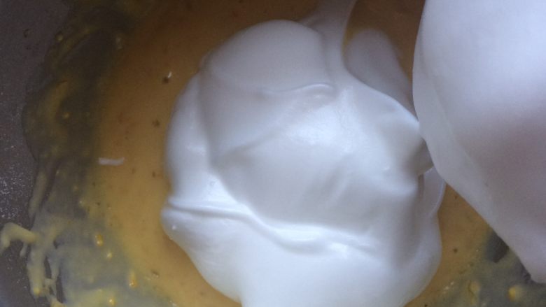 香橙蛋糕,将三分之一打发好的蛋白加到蛋黄糊中，翻拌均匀后倒入剩余的蛋白中，翻拌均匀。