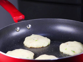 土豆饼的家常做法，吃起来特别过瘾,锅烧热，倒入多一些的植物油，将土豆饼下锅煎。