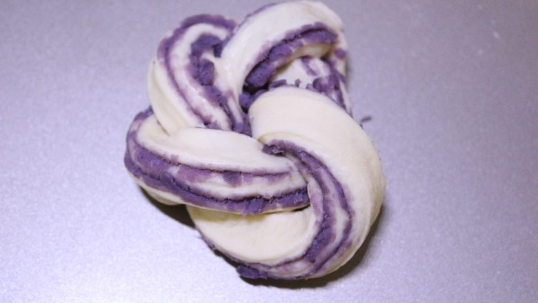 汤种紫薯花卷面包,再将长的另一端穿进结中，再将两端相接捏紧，整理好