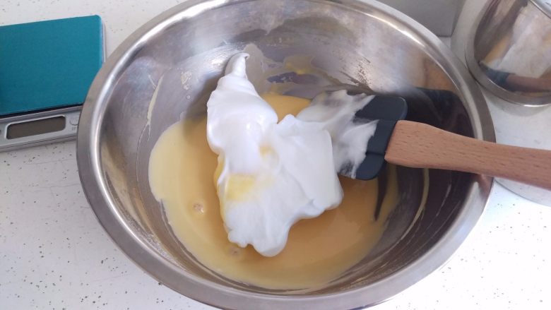 荔枝甜酒蛋糕,取蛋白的1/3放入蛋黄糊中，搅拌均匀。