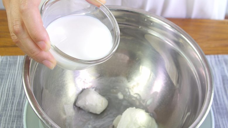 百香果慕斯蛋糕,打蛋盆隔热水。倒入奶酪分多次加入牛奶和百香果汁搅拌至顺滑。
