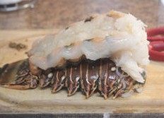巴西龙虾,将虾肉放在壳上，然后将尾巴打开，放在烤盘中