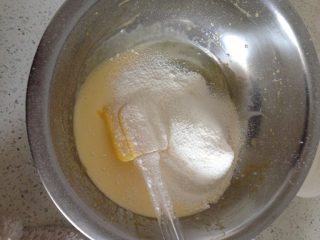 肉松蛋糕卷,如图：筛入低粉，泡打粉上下拌匀。
