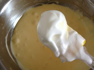 肉松蛋糕卷,如图：舀3／1蛋清加入蛋黄糊上下搅拌均匀。